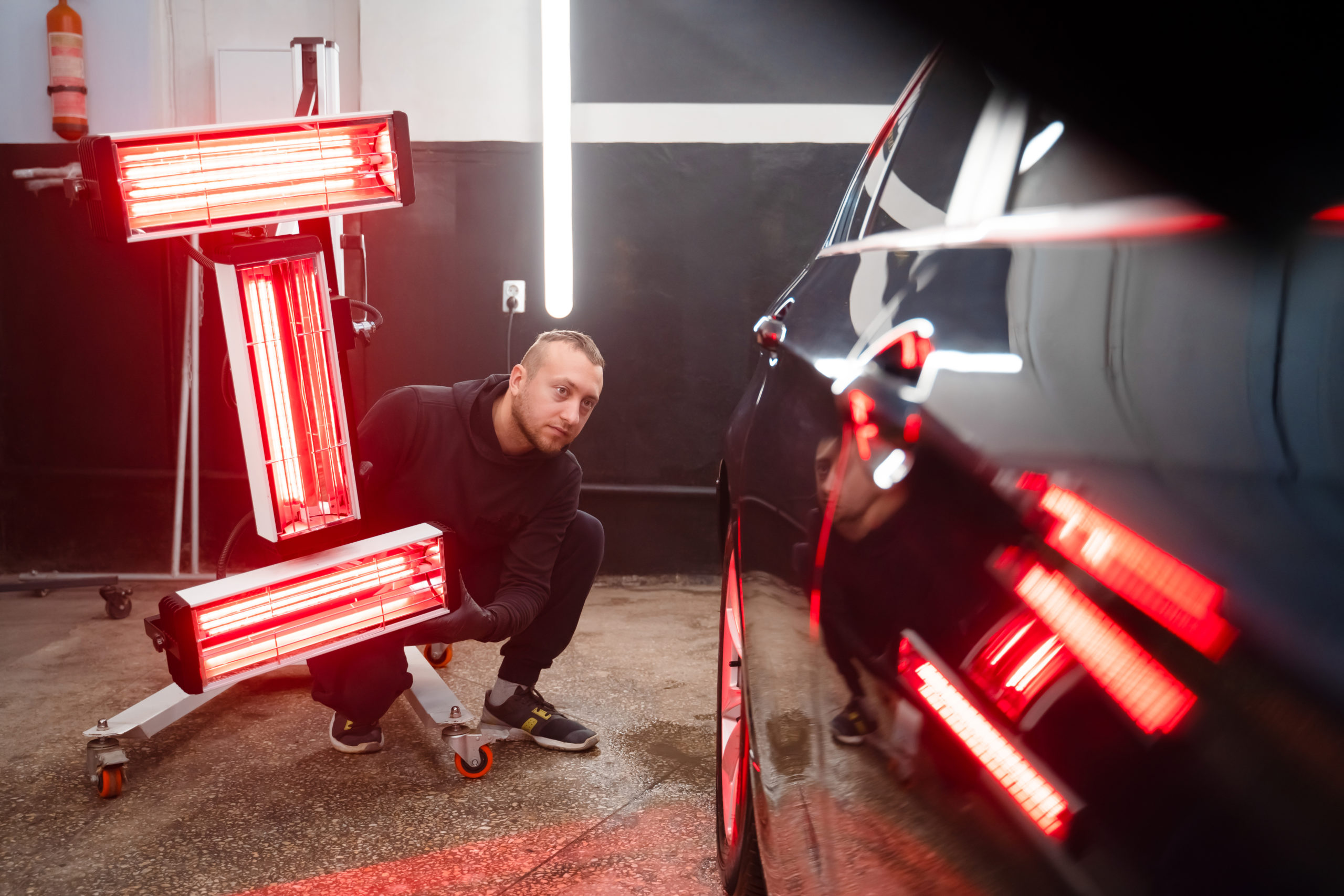 Taller de coches Plasencia detailing worker with infrared lamps near the car 2023 11 27 05 31 59 utc scaled